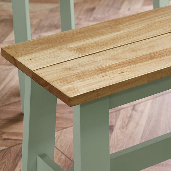 Wooden table with green legs on a wooden floor