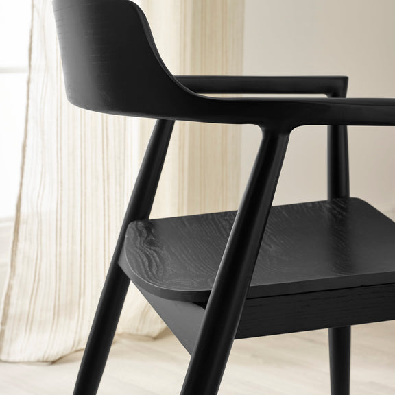 Black chair with a blurred curtain background