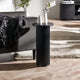 Black side table with decorative items in a living room setting