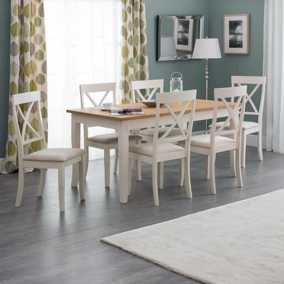 Dining room with a wooden table and white chairs against a green wall.