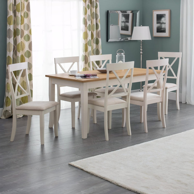 Dining room with a wooden table and white chairs against a green wall.