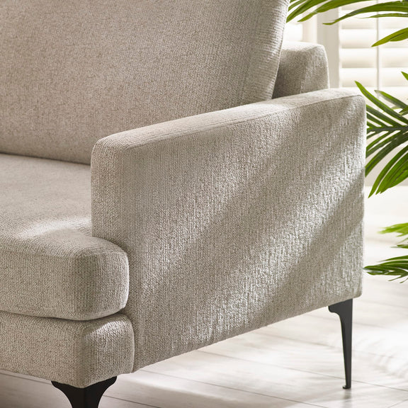 Gray armchair with textured fabric in a bright room with plants