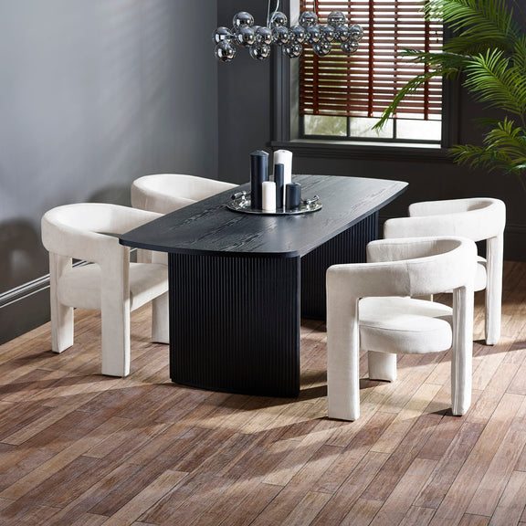 Modern dining room with a black dining table and white chairs on a wooden floor.