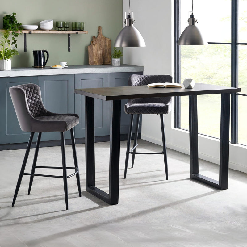 Modern kitchen with a black dining table and gray bar stools.