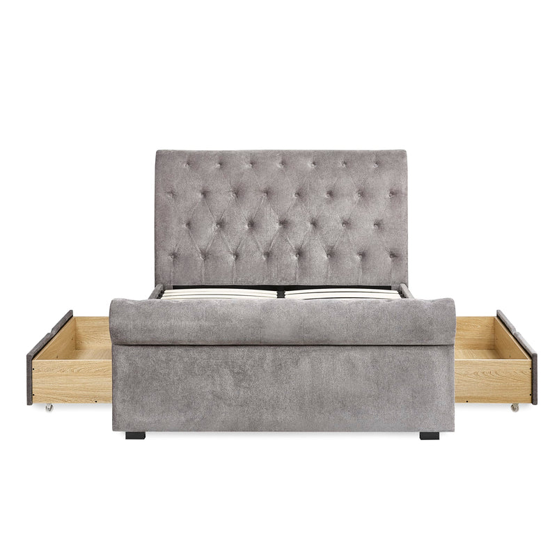 Gray upholstered bed with wooden drawers on a white background