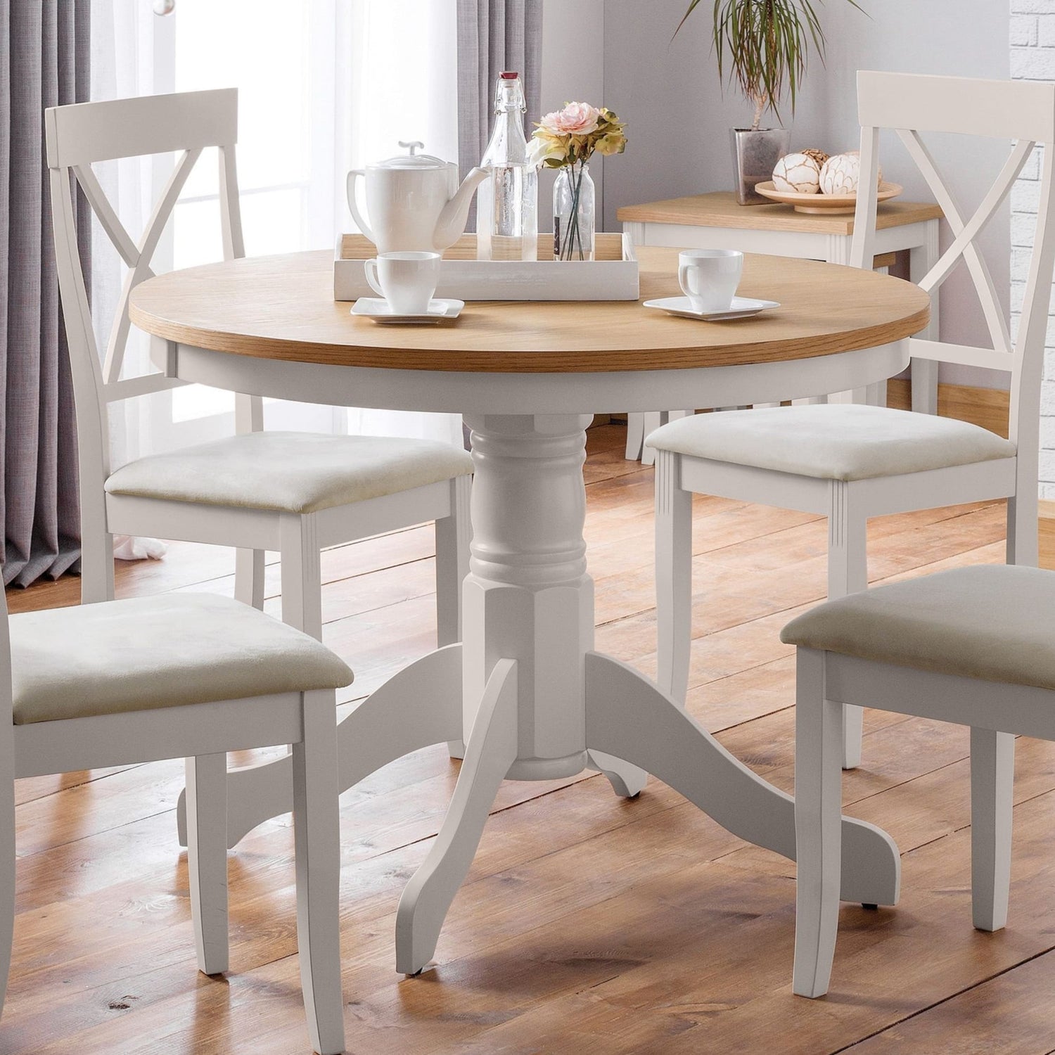 Dining table with chairs in a room with light-colored walls and wooden flooring.