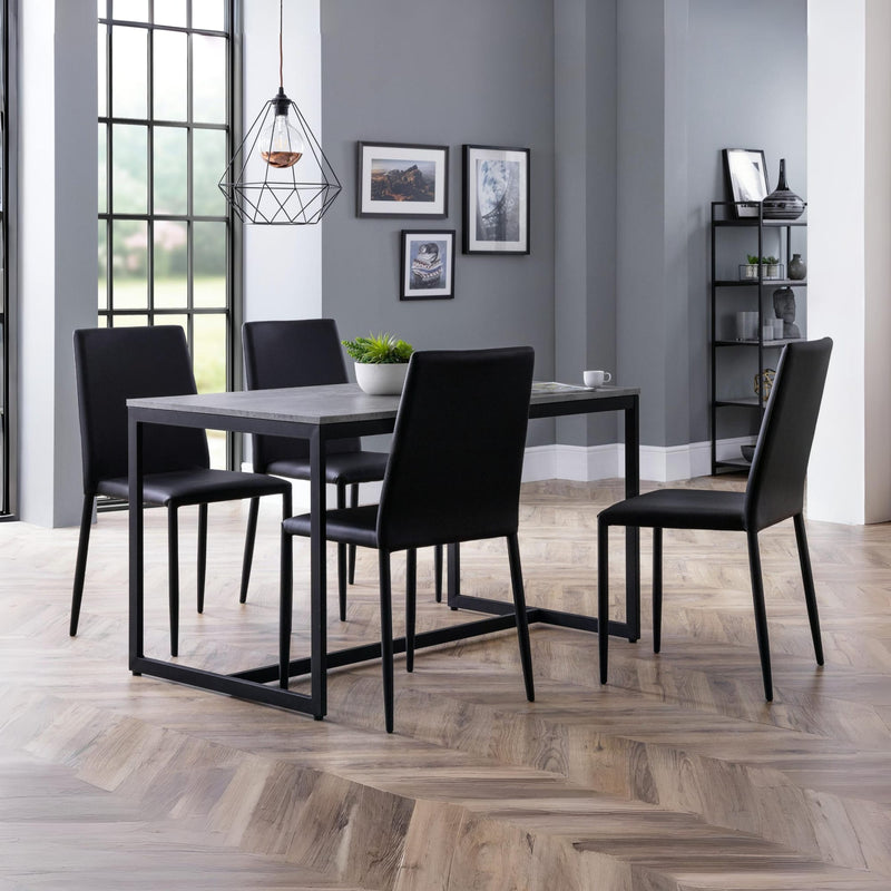 Dining room with a black dining table and chairs on a wooden floor.