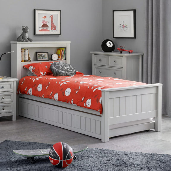 Children's bedroom with a white bed, red bedding, and various toys.