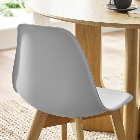 Gray chair in front of a wooden table with a blurred background
