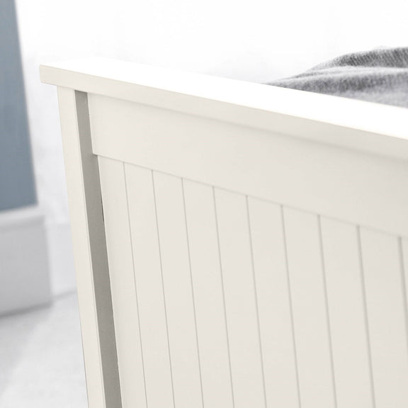 Close-up of a white wooden headboard with a blurred background
