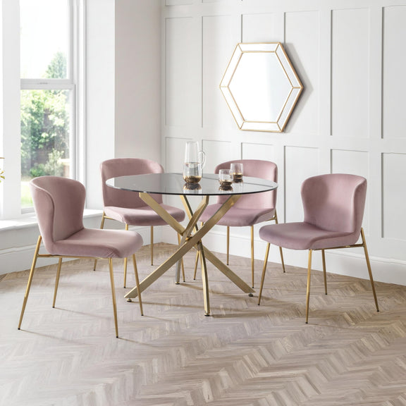 Dining room with pink chairs and a glass table against a white paneled wall.
