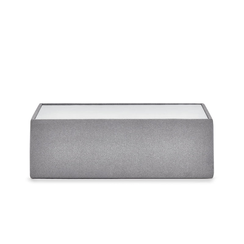 Gray fabric ottoman with glass top on a white background