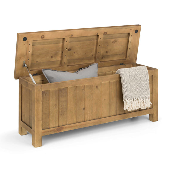 Wooden storage bench with a blanket and pillow on a white background