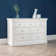 White dresser with decorative items against a blue wall