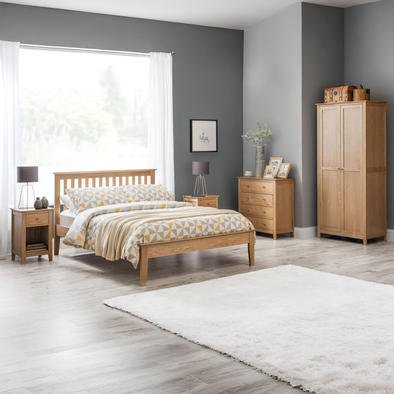 Wooden bedroom furniture set with bed, wardrobes, and nightstands in a room with gray walls and a window.