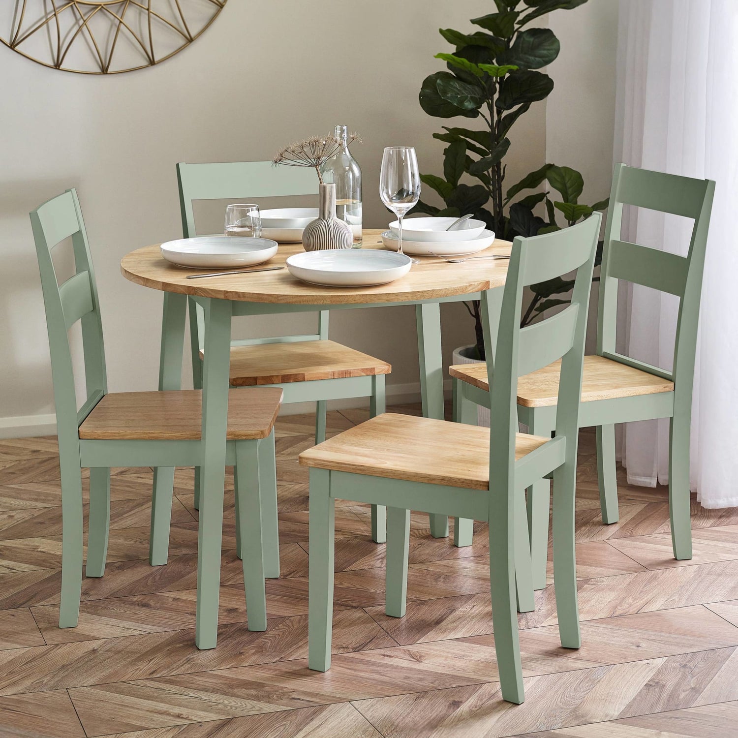 Dining table set with chairs in a room with a plant and decorative wall piece.