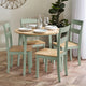 Dining table set with chairs in a room with a plant and decorative wall piece.