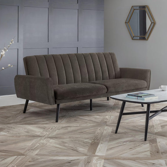 Brown sofa in a room with a hexagonal mirror on the wall.