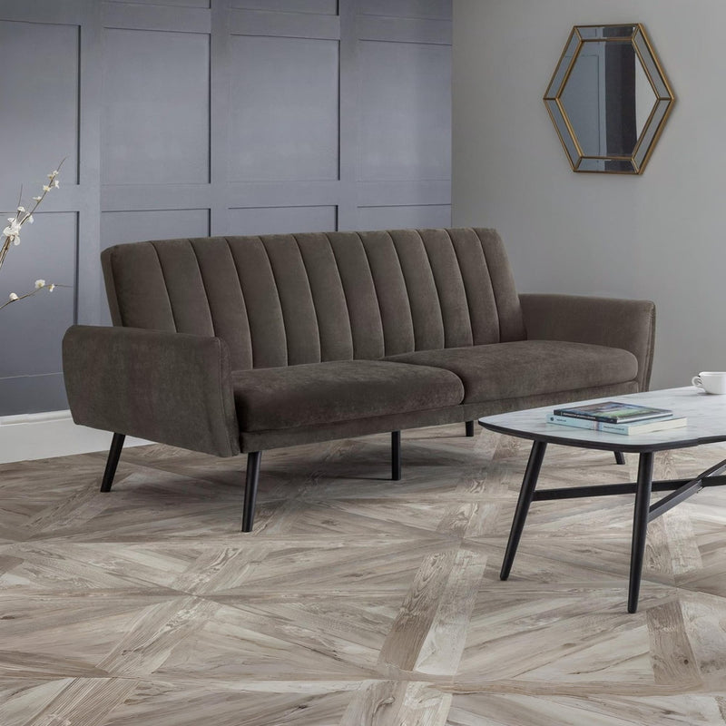 Brown sofa in a room with a hexagonal mirror on the wall.