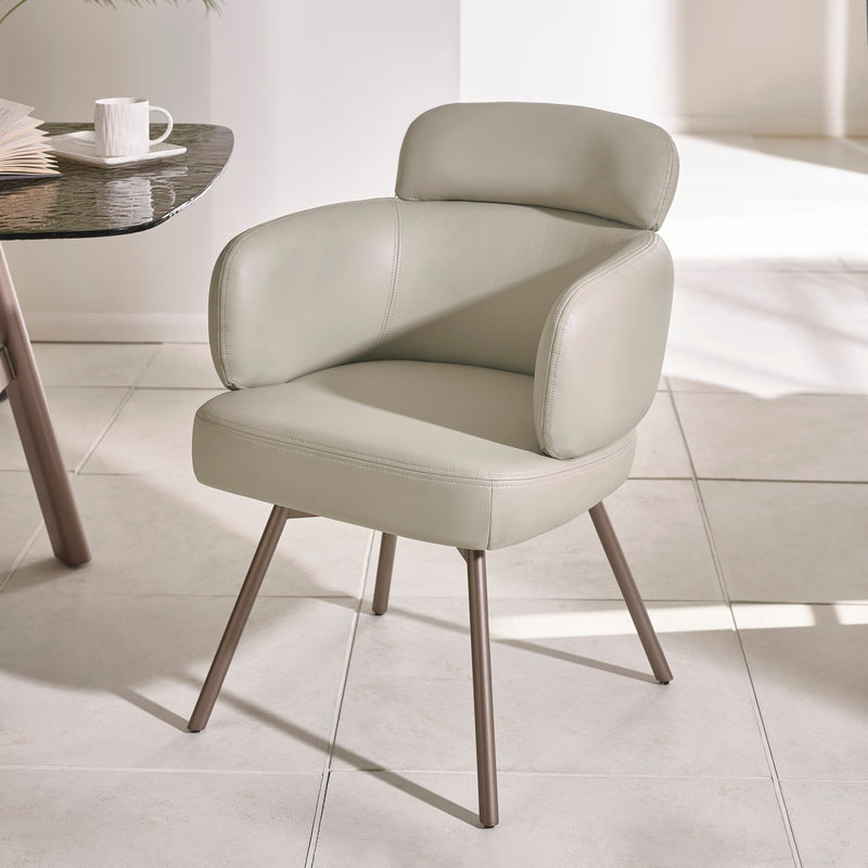 Modern beige chair with metal legs on a light tiled floor.