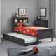 Children's bedroom with a black bed, red and white bedding, and sports balls on the floor.