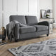 Gray sofa in a living room with a patterned rug and decorative items.
