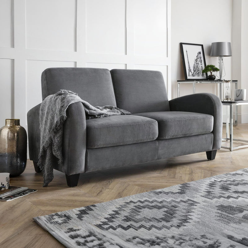 Gray sofa in a living room with a patterned rug and decorative items.