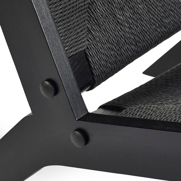 Close-up of a black metal chair with woven backrest on a white background