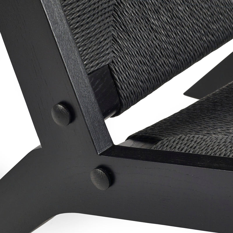 Close-up of a black metal chair with woven backrest on a white background