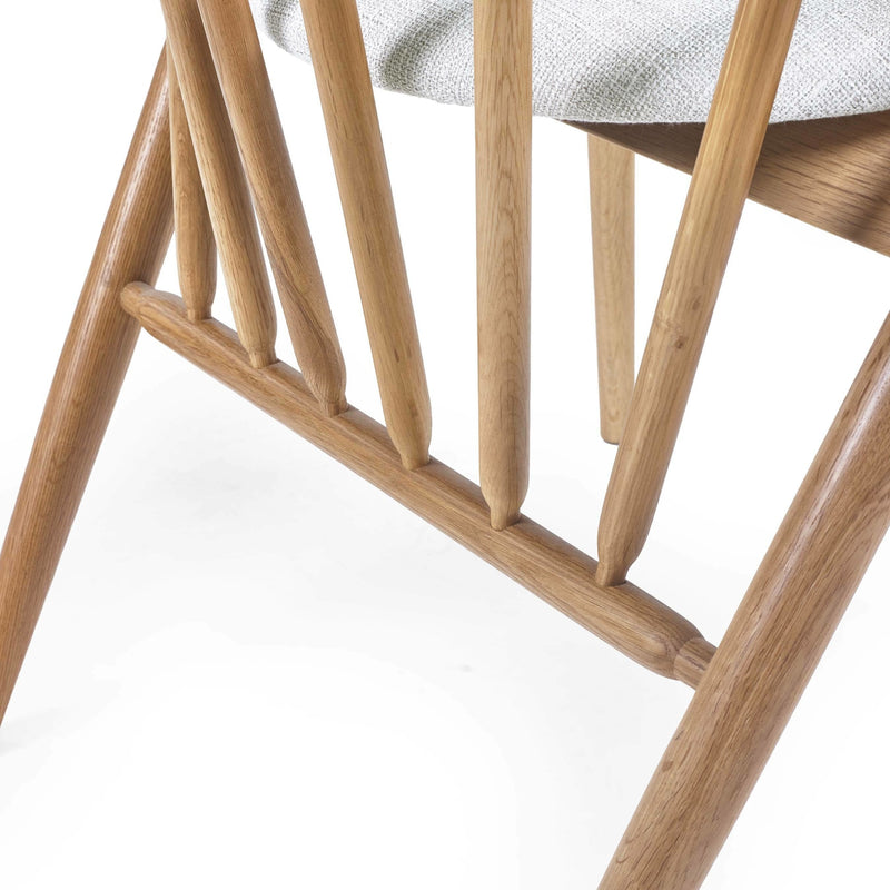 Close-up of a wooden chair with a white cushion on a white background