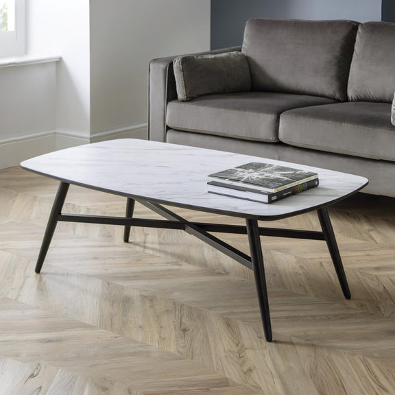 Modern living room with a gray sofa and a coffee table on a wooden floor.