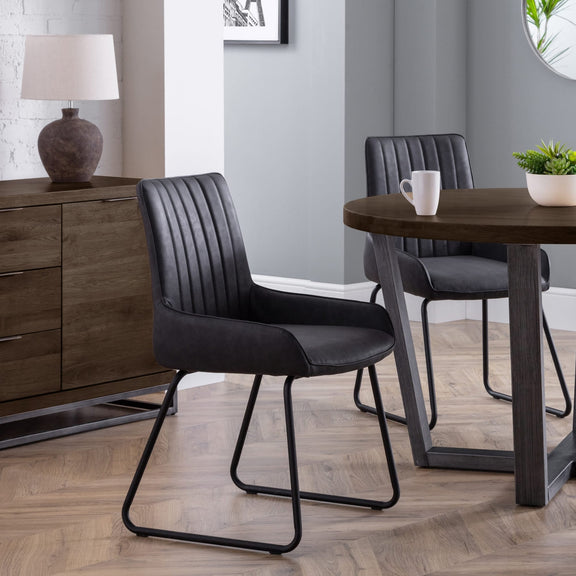 Dining room with black chairs, a wooden table, and a lamp.