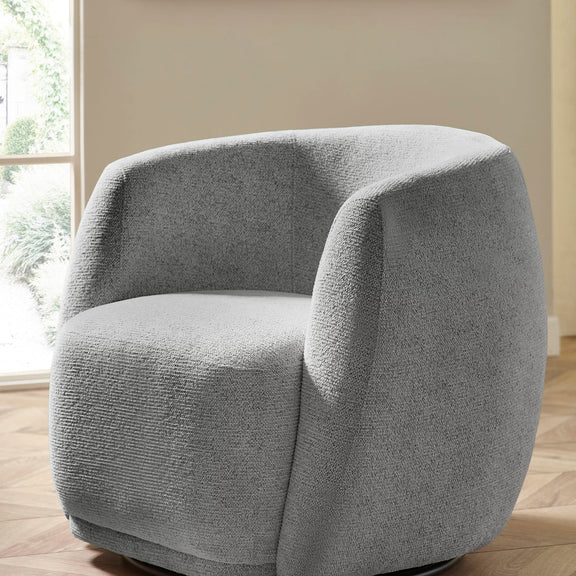 Gray textured armchair in a room with a window and beige walls.