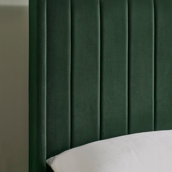 Green velvet headboard with a textured finish on a neutral background