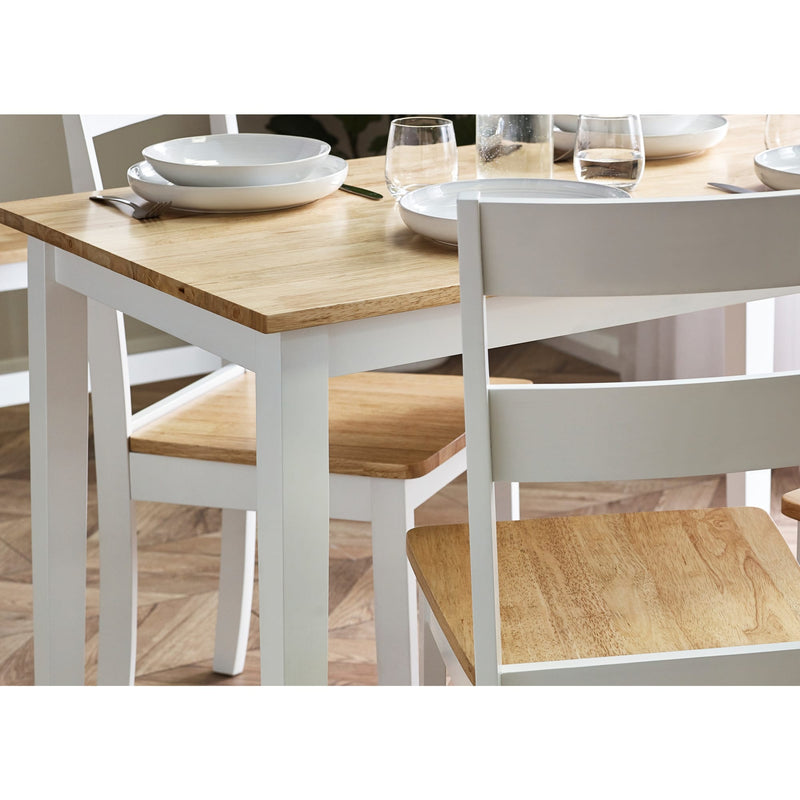 Dining table set with wooden surface and white chairs on a wooden floor.