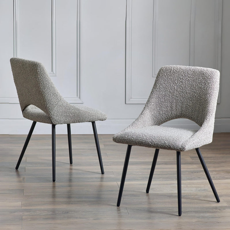 Two gray textured chairs with black legs on a wooden floor.
