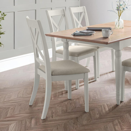 Dining table with four chairs in a room with wooden flooring and a window.