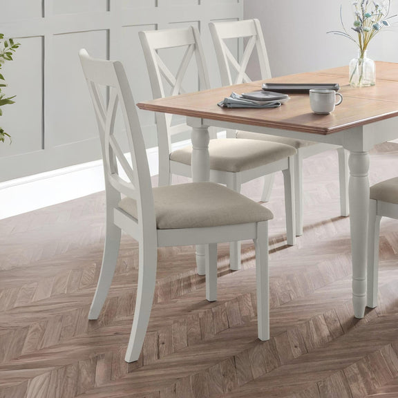 Dining table with four chairs in a room with wooden flooring and a window.