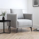 Gray armchair in a modern living room with a side table and plant.