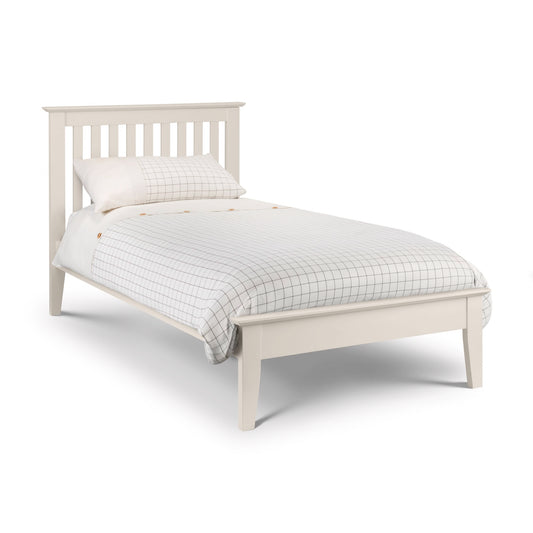 White bed with checkered bedding on a white background