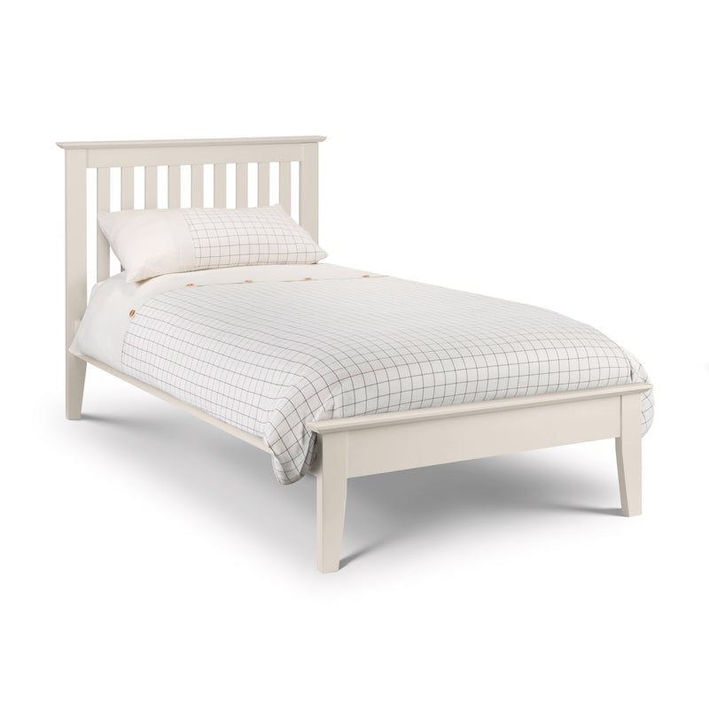 White bed with checkered bedding on a white background