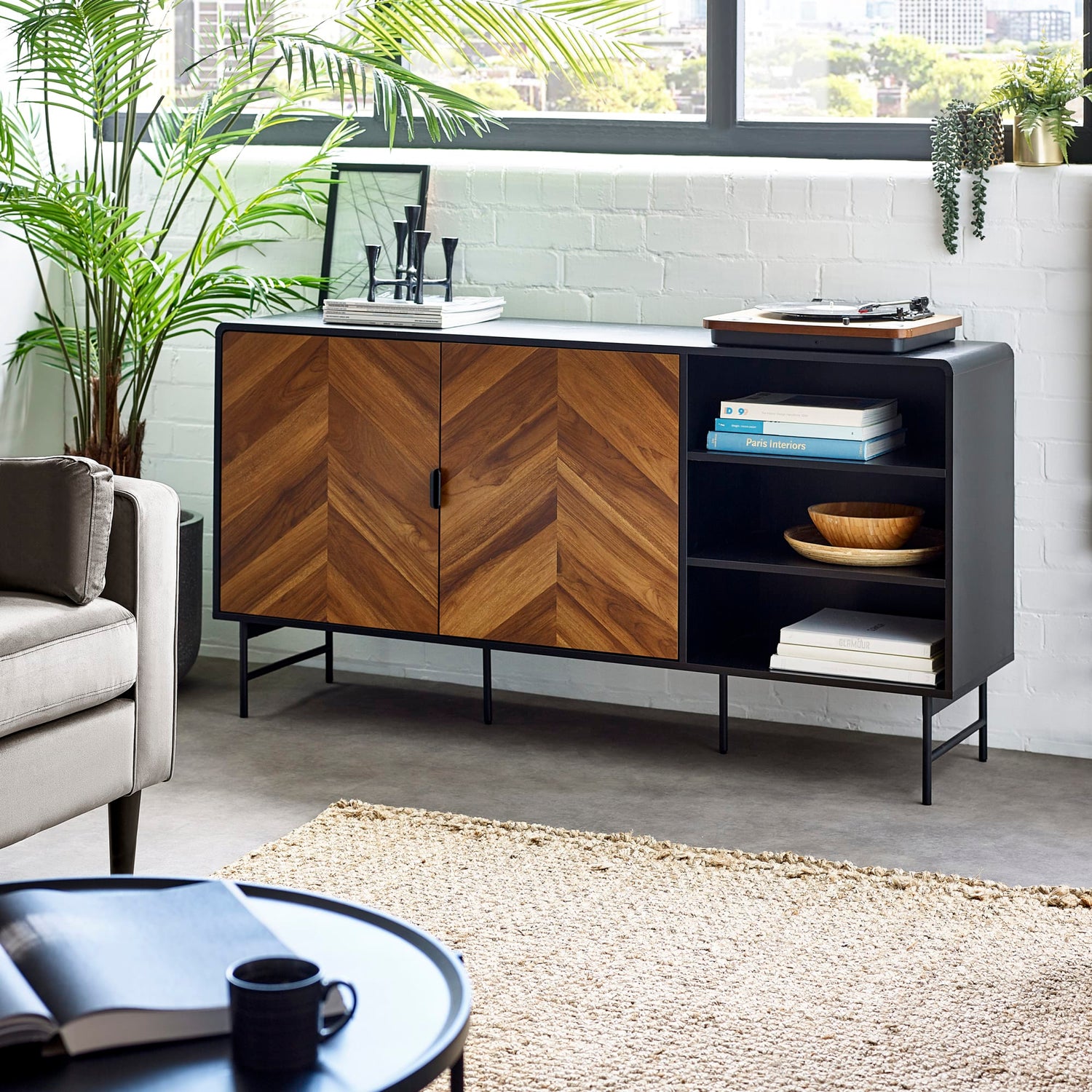 Modern living room with a wooden and black sideboard, sofa, and coffee table.