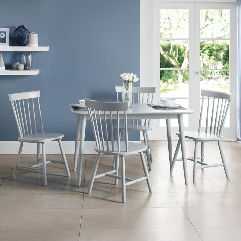 Dining room with gray table and chairs against a blue wall.