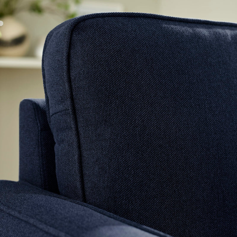 Close-up of a navy blue upholstered chair with a blurred background