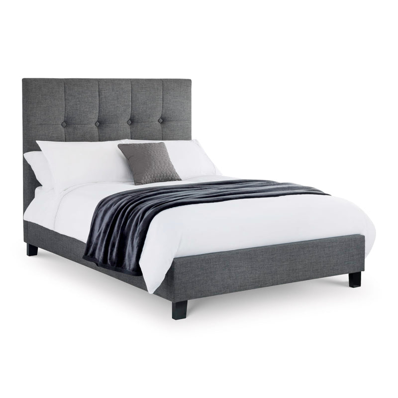 Gray upholstered bed with white bedding on a white background