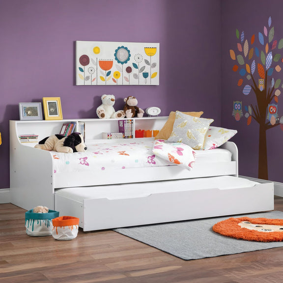 Children's room with a white bed, toys, and decorative elements on a purple wall.