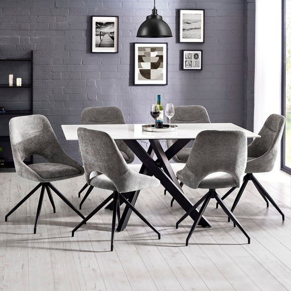 Dining room with a round table and gray chairs against a gray brick wall.
