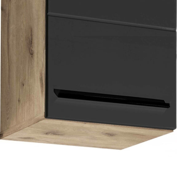 Corner of a piece of furniture with black glass panel and wooden frame