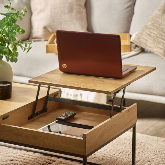 Wooden coffee table with a laptop on top in a living room setting