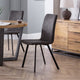 Dining room with wooden table, chairs, and a lamp on a wooden cabinet.